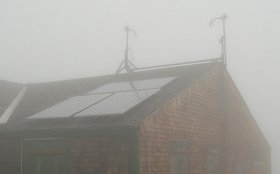 a picture of solar panels on a roof in some cloudy weather